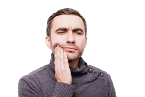 Tooth pain when to see a dentist illustrated by a man holding his jaw due to severe tooth discomfort