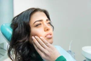 TMJ treatment in Billings MT illustrated by a patient experiencing jaw pain and facial discomfort during a dental visit